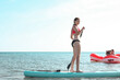 © Татьяна - Beautiful teen girl floating on a blue sup board, practicing paddle. The concept of water sports, relaxation, summer holidays, self-immersion. Teenager alone on board against background of water, sea.