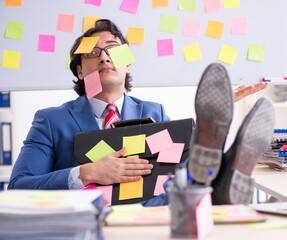 Wall Mural - Young male handsome employee in conflicting priorities concept