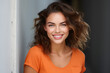 © yusraa_designz - beautiful female model wearing orange shirt smiling looking into the camera on clear background, portrait of a woman smiling