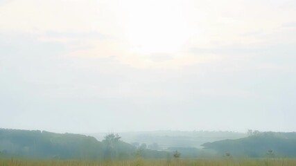Wall Mural - a brilliant sun sets over a serene landscape, filling the sky with warm hues and creating a peaceful