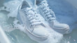 © Nemanja - Closeup of pair of white shoes sneakers wash in water and foam. Dirty or clean footwear