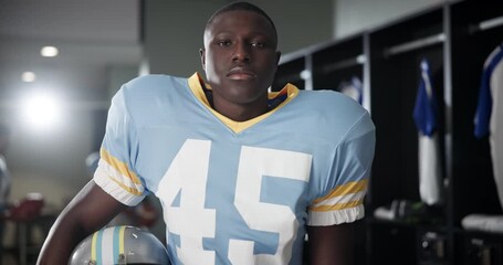 Poster - Black man, American football and helmet in locker room for sport, face and ready for game in competition. Serious person, athlete and player in portrait for contest, club and franchise in Florida