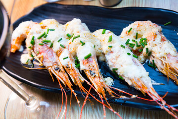 Wall Mural - Cooked deliciously shrimps with parmesan cheese and greens served at plate