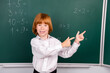 © deagreez - Photo of lovely small schoolboy point empty space dressed stylish uniform classroom blackboard background
