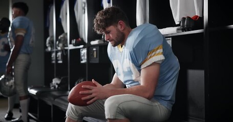 Wall Mural - Serious man, football player and thinking with ball in locker room for match, game or half time. Young male person or athlete getting ready or preparation for ideas, sports tournament or competition