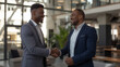 © Rattanapon - African American businessman shaking hands with partner. Two black businessmen shaking hands.