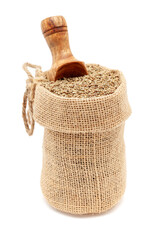 Wall Mural - Close-up of Organic Carom seeds (Trachyspermum ammi) or Ajwain, in a jute bag with a scoop, Isolated on a white background.