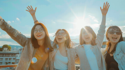 Happy Asian women with arms up in the air outdoors in city showing freedom and open minded people, female friends having fun supporting their community and friendship bounding during travel together