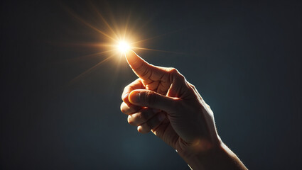 A hand is holding a bright light, with three fingers extended, against a dark background.

