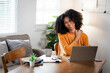 © NAMPIX - Overworked young Black businesswoman is massaging her neck, sitting at home office, experiencing neck pain, and feeling exhausted during work.