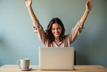 A girl sits at a table in front of a laptop, stretching, raising her arms to warm up.