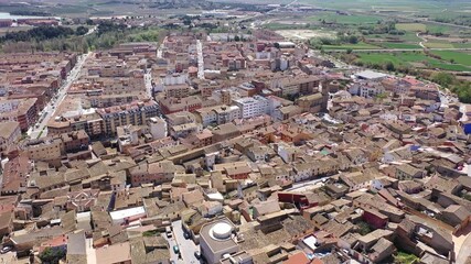 Wall Mural - Aerial view of Spanish town of Ejea de los Caballeros in province of Zaragoza overlooking brownish tiled roofs of residential buildings and Church de Santa Maria de la Corona on sunny spring day