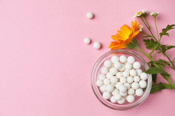 Wall Mural - Homeopathic remedy. Pills in glass bowl, calendula and chamomile flowers on pink background, flat lay. Space for text