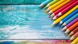 © James - Colourful wax crayons pencils on white wood table isolated on colorful background