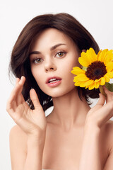 Canvas Print - Beautiful young woman holding a sunflower on a white background