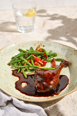 Poster - Duck Leg Confit with Berry Sauce and Green Bean Garnish on Elegant Plate with Water Glass