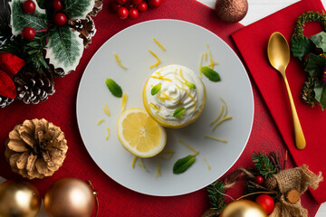 Wall Mural - Delicious dessert of lemon mousse with cream on a table with christmas decoration