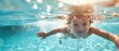 © Nuttapong - A child learning to swim with the help of an instructor, splashing in a clear pool with a supportive environment