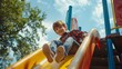 © The Little Hut - Young boy enjoys a sunny day at the playground sliding down a colorful slide : Generative AI