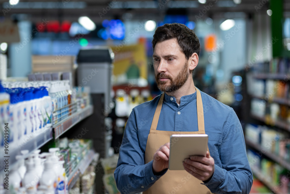 Store Employee Using Digital Tablet To Check Inventory In Supermarket Store Employee Using Digital Tablet To Check Inventory In Supermarket