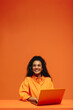 © Jacob Lund - Smiling customer care representative in vibrant monochromatic office setting with headset and laptop