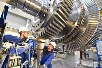 professional industrial teamwork - workers manufacturing steam turbines in an industrial factory