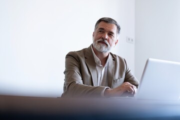 Sticker - Portrait of mature man sitting at his desk in the modern office.