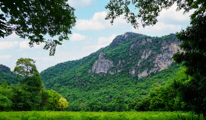 View of scenic landscape of mountains with green forest landscape and cloudy blue sky at Phu pha man National Park, Khon kaen, Thailand.