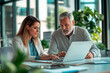 © GustavsMD - Senior man and young woman collaborating on a laptop in a modern office. Professional indoor portrait photography. Business and teamwork concept. Design for banner, poster, header