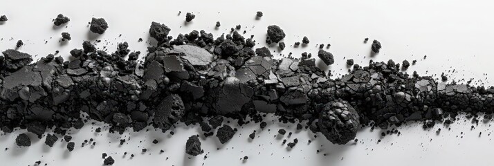 Aufkleber - A scattered assortment of broken black rocks lies on a smooth white surface, illuminated by natural light in a well-lit environment