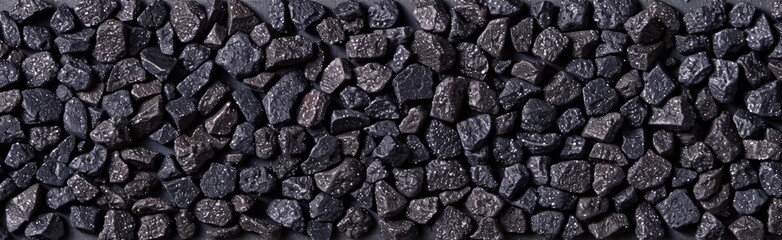 Aufkleber - Small black gravel stones arranged in a uniform pattern, perfect for pathways and decorative garden layouts