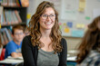 © Kowit - A woman with glasses is smiling in a classroom