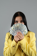 Canvas Print -  business woman wear yellow suit holding dollar money isolated on grey