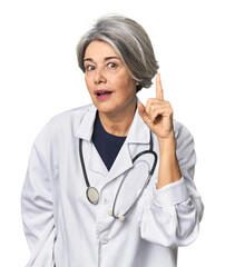 Caucasian mid-age female doctor with stethoscope having an idea, inspiration concept.