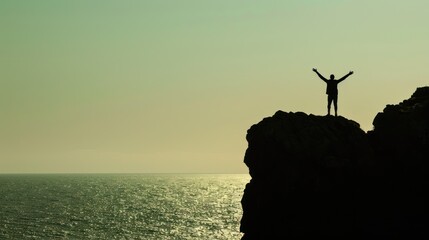 Wall Mural - Silhouette of a person standing on a cliff with arms outstretched.