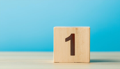 Fototapete - Wooden cube with number 1 one on wooden table with blue wall on background. Close-up.