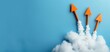 © Arrseman - Orange arrows launching into the sky from clouds, symbolizing growth, progress, and success against a blue background.