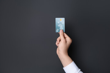 Canvas Print - Man holding credit card on black background, closeup