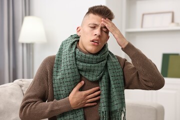 Wall Mural - Cold symptom. Young man suffering from fever at home