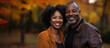 © MonkaLemonka - portrait of middle age african american couple standing outside; autumn/fall forest as a background; black husband & wife standing outside and hugging; copy space
