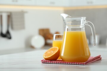 Wall Mural - Tasty orange juice in jug, glass and citrus fruit on white marble table. Space for text