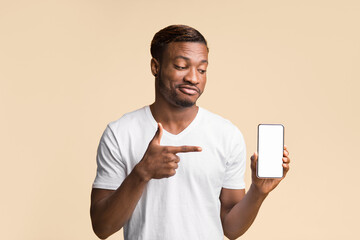 Aufkleber - Mobile App. Black Guy Pointing Finger At Cellphone Empty Screen In His Hand Standing Over Yellow Background. Studio Shot, Mockup