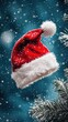 © Uliana - A Santa hat against a snowy winter background.