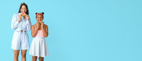 Sticker - Beautiful young African-American woman and her cute daughter eating pieces of fresh watermelon on blue background