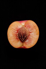 Poster - A juicy half eaten peach sits on a dark background