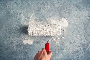 Poster - A person paints a wall with a roller