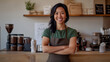 © Anna - An Asian woman wearing a green shirt and apron, smiling confidently while standing in her well-organized coffee shop, showcasing professionalism and warmth.