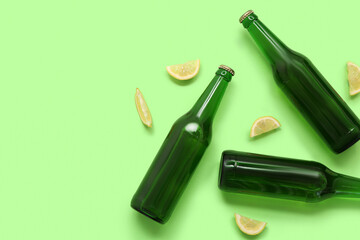 Wall Mural - Bottles of fresh beer with lemon on green background