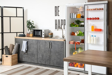 Canvas Print - Open fridge full of fresh food near white wall in kitchen