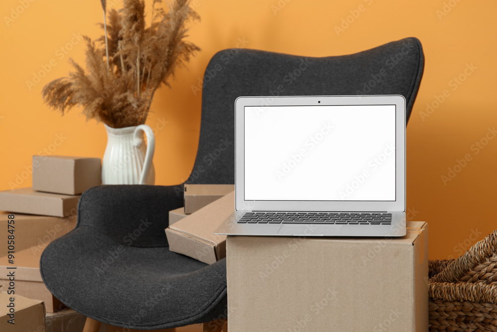 Blank laptop on moving box in room, closeup